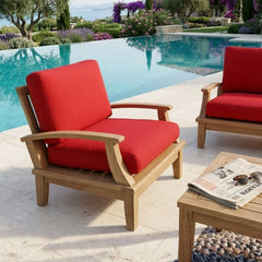Anderson Teak Brianna deep seating armchair in a stylish outdoor patio setting with lush garden background.