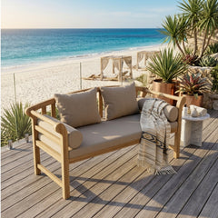 Anderson Teak Brisbane deep seating outdoor sofa with plush cushions, shown in a natural garden setting with vibrant designer color options.