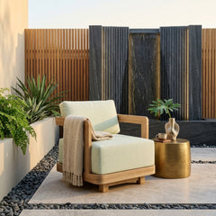 Anderson Teak Granada swivel armchair with deep outdoor seating, shown in a stylish garden setting with vibrant color options.