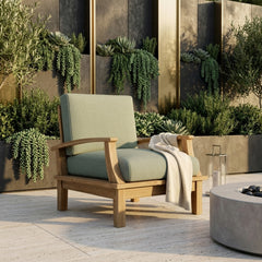 Anderson Teak Brianna deep seating armchair in outdoor patio setting, showcasing plush cushion and stylish design in six colors.