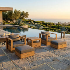 Set of two teak wood armchairs and two ottomans from Anderson Teak in a garden patio setting, featuring deep seating and designer colors.