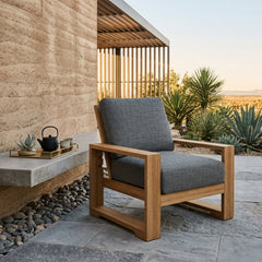 Anderson Teak Capistrano deep seating armchair in outdoor garden setting, showcasing luxurious design and available in 9 designer colors.