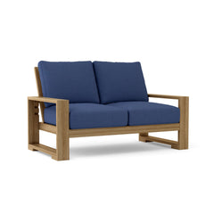 Anderson Teak Capistrano deep seating loveseat in one of nine designer colors, featuring plush cushions and stylish outdoor design.