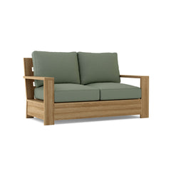 Anderson Teak Madera Deep Seating Loveseat in one of nine designer colors, showcasing a stylish teak wood frame and plush cushions.
