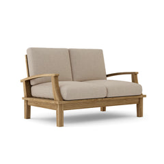 Anderson Teak Brianna deep seating loveseat in a designer color, featuring plush cushions and stylish armrests for outdoor lounging.