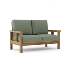 SouthBay deep seating teak wood loveseat by Anderson Teak, shown in cast pomegranate, with a stylish outdoor patio setting.