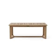 Anderson Teak 11-piece Catania outdoor dining table set with teak finish and colorful cushions on a patio.