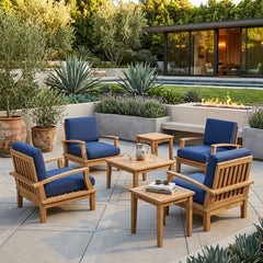 Anderson Teak Brianna teak wood outdoor deep seating set with 4 armchairs and 2 tables in a garden patio setting.