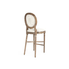 Zentique medallion cow hide accent bar stool with a wooden frame, featuring a padded seat and decorative upholstery details.